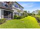 Manicured backyard featuring a screened lanai, lush lawn, and privacy hedge at 1561 Corkery Ct, Winter Springs, FL 32708