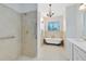 Bathroom featuring a soaking tub, tiled shower, and elegant fixtures at 1561 Corkery Ct, Winter Springs, FL 32708