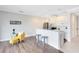 Open living space with a kitchen, bar seating, and cozy yellow armchair and ottoman at 1561 Corkery Ct, Winter Springs, FL 32708