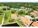 Stunning aerial view of villa community, golf course, pool, and tennis courts surrounded by lush greenery at 1565 Corkery Ct, Winter Springs, FL 32708