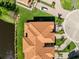 Overhead view of a villa roof, showcasing the lush landscaping and nearby pond within the community at 1565 Corkery Ct, Winter Springs, FL 32708
