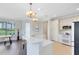 Bright, open kitchen with tile floor, stylish light fixtures, modern appliances, and a breakfast bar overlooking the dining area at 1565 Corkery Ct, Winter Springs, FL 32708