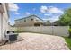 Paver patio in fenced backyard with lawn and air conditioning unit along the side of this two-story home at 1613 Sapphire Star Dr, Oviedo, FL 32765