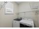 Functional laundry room with modern washer and dryer and plenty of shelf space for storage at 1613 Sapphire Star Dr, Oviedo, FL 32765