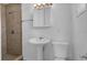 Bright bathroom features a tiled shower, pedestal sink and a modern, clean look at 1725 Marcia Dr, Orlando, FL 32807