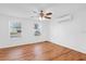 Bedroom with wood-look floors, ceiling fan, and two bright windows overlooking the lawn at 1725 Marcia Dr, Orlando, FL 32807