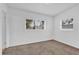 Bedroom with plush carpet, natural light from two windows, and freshly painted white walls at 1725 Marcia Dr, Orlando, FL 32807