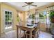 Dining room with neutral tile flooring, a ceiling fan, and natural light from three windows and a glass door at 1725 Marcia Dr, Orlando, FL 32807