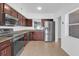 Modern kitchen featuring stainless steel appliances, dark wood cabinets, and tiled flooring at 1725 Marcia Dr, Orlando, FL 32807