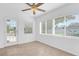 Sunlit living room with neutral tile flooring and natural light from large windows and a glass door at 1725 Marcia Dr, Orlando, FL 32807
