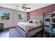 Main bedroom features a decorative headboard, bright windows, and a ceiling fan at 1725 Marcia Dr, Orlando, FL 32807