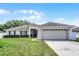 Charming one-story home with a well-manicured lawn, mature landscaping, and an attached two-car garage at 1802 Hagen Ct, St Cloud, FL 34771