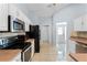 This kitchen boasts stainless steel appliances, tile backsplash, and a view to the front door at 1802 Hagen Ct, St Cloud, FL 34771