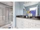 Modern bathroom featuring dual sinks, granite countertops, and a glass-enclosed shower, offering a sleek and functional design at 1864 Nice Ct, Kissimmee, FL 34747
