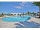 Large community pool with splash pad, umbrellas, lounge seating and mature landscaping on a sunny day at 1864 Nice Ct, Kissimmee, FL 34747