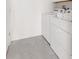 Bright laundry room features a stacked washer and dryer, tile floor and shelving for storage at 1864 Nice Ct, Kissimmee, FL 34747