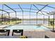 Relaxing screened-in pool with a serene lake view, inviting you to unwind in the refreshing water at 1864 Nice Ct, Kissimmee, FL 34747