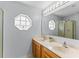 Bathroom featuring a double vanity with updated fixtures, an octagonal window, and a walk-in shower at 1942 N Portillo Dr, Deltona, FL 32738