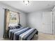 Bright bedroom featuring a window, door, and bed with blue striped bedding, providing a restful retreat at 1942 N Portillo Dr, Deltona, FL 32738