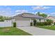 Single Gathering home featuring solar panels and landscaped front yard with a well-maintained lawn and two-car garage at 1942 N Portillo Dr, Deltona, FL 32738