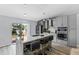 Modern kitchen with gray cabinets, stainless steel appliances, barstool seating, and a sliding glass door to the backyard at 1942 N Portillo Dr, Deltona, FL 32738