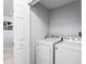 Functional laundry room with white washer and dryer, offering convenience and efficiency at 1942 N Portillo Dr, Deltona, FL 32738