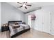 Comfortable bedroom featuring wood-look flooring, neutral colors, a ceiling fan, and an ensuite bathroom at 1942 N Portillo Dr, Deltona, FL 32738