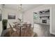 Modern dining room with stylish light fixture, gray-toned wood floors, and view to the living room at 2015 N Hastings St, Orlando, FL 32808