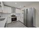 Well-lit kitchen featuring new stainless steel appliances, white cabinets, and modern subway tile backsplash at 2015 N Hastings St, Orlando, FL 32808