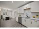 Bright kitchen featuring white cabinets, stainless appliances, subway tile backsplash, and view to dining area at 2015 N Hastings St, Orlando, FL 32808