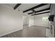 Large living room with fireplace, black ceiling beams, gray-toned wood floors, and view to the dining room at 2015 N Hastings St, Orlando, FL 32808
