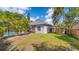 Great backyard with mature trees and partial view of screened lanai and pool area at 203 Red Bud Ct, Lake Mary, FL 32746