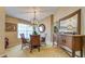 Dining room featuring a glass table, wicker chairs, and stylish chandelier under a high ceiling at 203 Red Bud Ct, Lake Mary, FL 32746