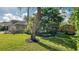 Manicured front yard with tropical trees and landscaping featuring a home with an attached two-car garage at 203 Red Bud Ct, Lake Mary, FL 32746