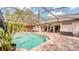 Inviting screened-in pool features beautiful brick pavers, lush landscaping, and a red umbrella at 203 Red Bud Ct, Lake Mary, FL 32746