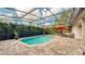Inviting screened-in pool features beautiful brick pavers, lush landscaping, and a red umbrella at 203 Red Bud Ct, Lake Mary, FL 32746