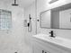 Modern bathroom showcases shower with glass blocks, black fixtures, and a vanity with mirror at 2225 E Welch Rd, Apopka, FL 32712