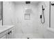 This bathroom features white marble-esque tile and dark fixtures and shower head, perfect for relaxing at 2225 E Welch Rd, Apopka, FL 32712