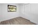 A clean and bright bedroom with wood floors, a black-framed window and closet with sliding doors at 2225 E Welch Rd, Apopka, FL 32712