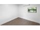 Well-lit room with laminate floors, white walls, AC unit, and a window with view of the backyard at 2225 E Welch Rd, Apopka, FL 32712