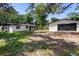 Exterior view of a white home with a black garage door and mature trees surrounding the property at 2225 E Welch Rd, Apopka, FL 32712