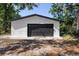 The garage is a detached structure with a black garage door and white siding at 2225 E Welch Rd, Apopka, FL 32712