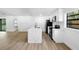 A well-lit kitchen features white cabinets, modern appliances, an island and an open floor plan at 2225 E Welch Rd, Apopka, FL 32712
