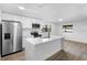 A well lit kitchen with white cabinets, stainless steel appliances, an island and wood flooring at 2225 E Welch Rd, Apopka, FL 32712