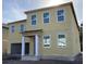 Two-story home featuring a neutral beige siding, white trim, large windows, and a two-car garage at 2286 Broadbrook Dr, St Cloud, FL 34771