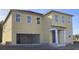 Two-story home featuring a neutral beige siding, white trim, large windows, and a two-car garage at 2286 Broadbrook Dr, St Cloud, FL 34771