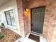 Inviting doorway with brick accents, featuring a warm light fixture and neutral door at 255 Sandlewood Trl, Winter Park, FL 32789