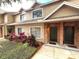Inviting townhome with well-maintained landscaping and brick accents around the front door at 255 Sandlewood Trl, Winter Park, FL 32789