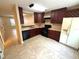 Traditional-style kitchen with tile flooring, dark cabinetry, and black appliances at 255 Sandlewood Trl, Winter Park, FL 32789