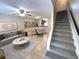 Open-concept living room featuring stylish furnishings, a ceiling fan, and stairs at 255 Sandlewood Trl, Winter Park, FL 32789
